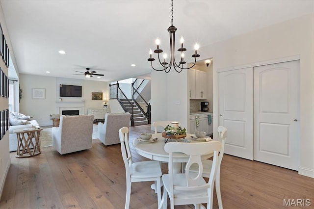 472 Cypress Creek Ln, Imperial, MO 63052 - dining room with stairway, a fireplace, wood-type flooring, ceiling fan, and a chandelier