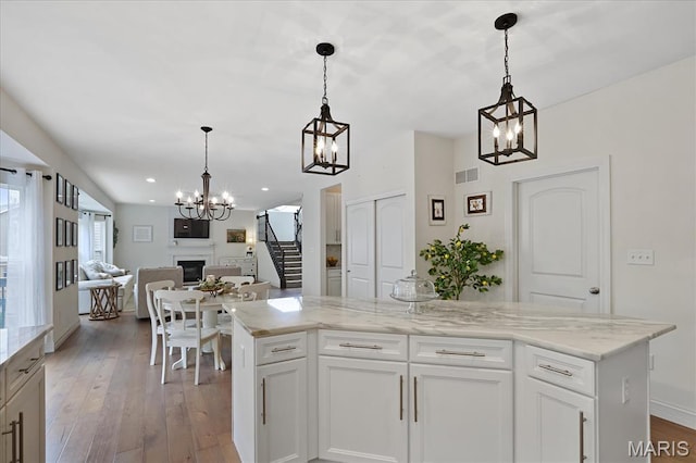 472 Cypress Creek Ln, Imperial, MO 63052 - kitchen with a chandelier, open floor plan, hardwood / wood-style flooring, a fireplace, and recessed lighting