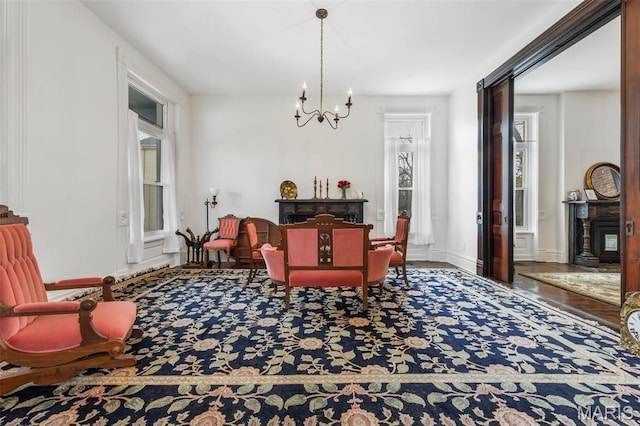 dining room featuring a chandelier, wood finished floors, and baseboards