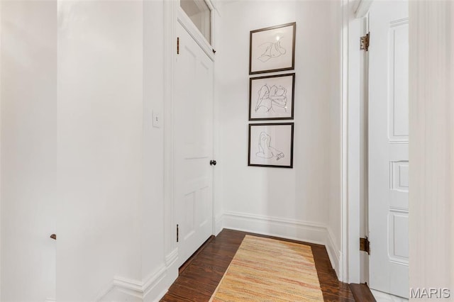 hall with baseboards and dark wood finished floors