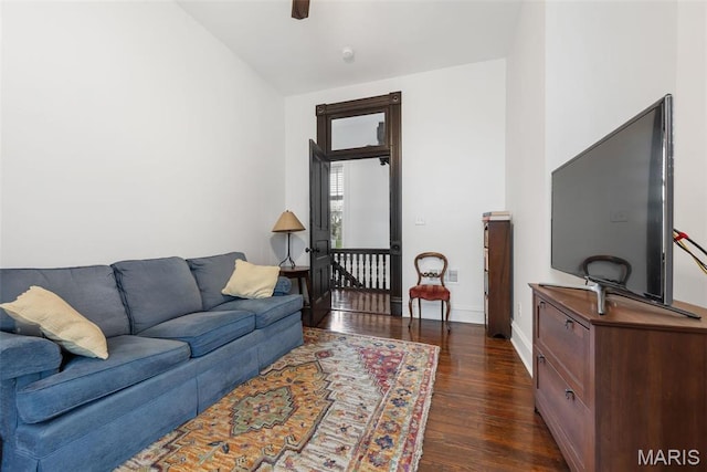 living area featuring dark wood-style floors, baseboards, ceiling fan, and vaulted ceiling