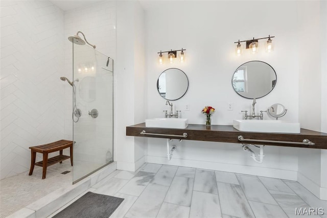 bathroom with a sink, a tile shower, marble look tiles, and baseboards