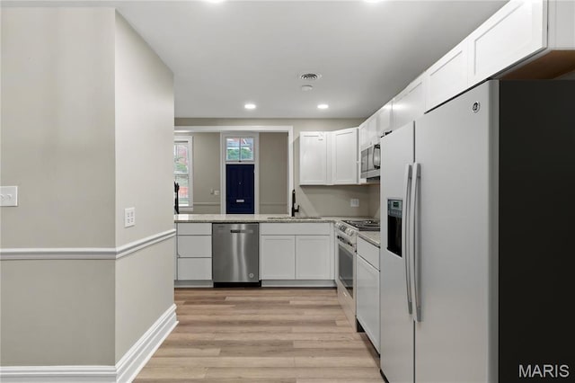 914 Russell Blvd, Saint Louis, MO 63104 - kitchen with stainless steel appliances, white cabinets, light wood-style flooring, and recessed lighting