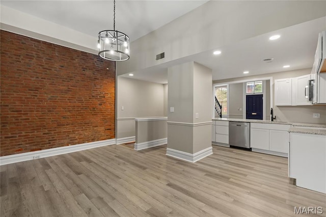 914 Russell Blvd, Saint Louis, MO 63104 - kitchen with appliances with stainless steel finishes, brick wall, white cabinets, light wood-style floors, and light stone countertops