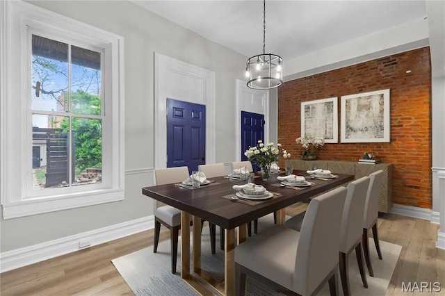 914 Russell Blvd, Saint Louis, MO 63104 - dining space with light wood-type flooring, a chandelier, and brick wall