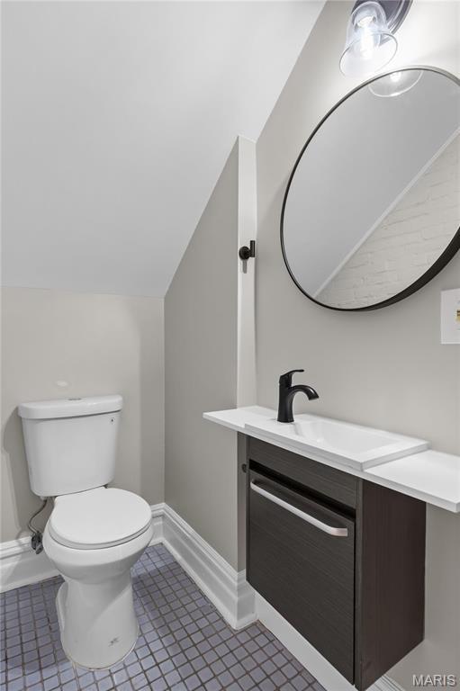 914 Russell Blvd, Saint Louis, MO 63104 - bathroom featuring vanity, vaulted ceiling, and tile patterned flooring