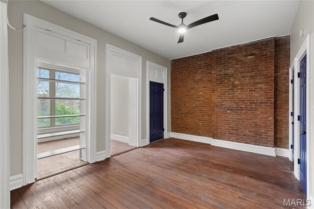 914 Russell Blvd, Saint Louis, MO 63104 - unfurnished bedroom featuring brick wall, hardwood / wood-style flooring, and a ceiling fan