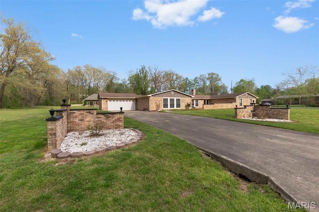 185 Garnet Ln, Cape Girardeau, MO 63701 - ranch-style home featuring asphalt driveway, an attached garage, a front lawn, and a chimney
