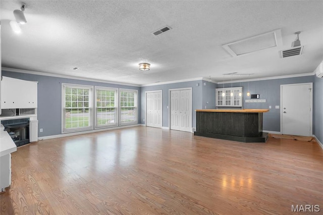 185 Garnet Ln, Cape Girardeau, MO 63701 - unfurnished living room with ornamental molding, a textured ceiling, baseboards, wood finished floors, and a fireplace