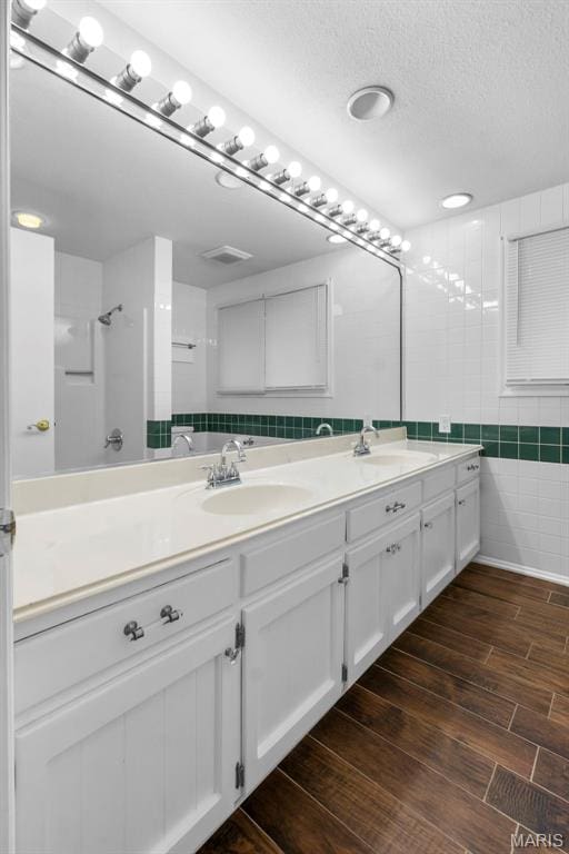 185 Garnet Ln, Cape Girardeau, MO 63701 - full bath with double vanity, wood finished floors, a textured ceiling, and tile walls