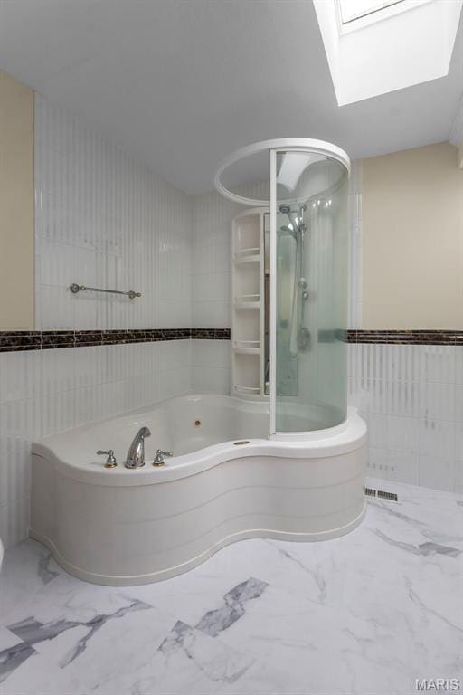 185 Garnet Ln, Cape Girardeau, MO 63701 - bathroom with tile walls, a whirlpool tub, marble look tile flooring, a shower with door, and a skylight