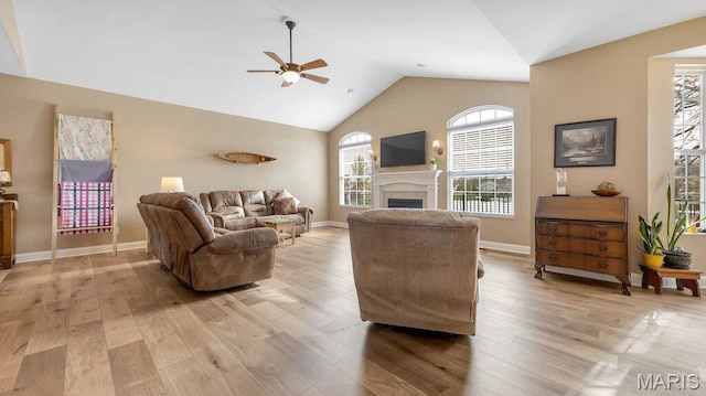 304 Wood Duck Ct, Waterloo, IL 62298 - living room featuring ceiling fan, a fireplace, light wood finished floors, baseboards, and high vaulted ceiling