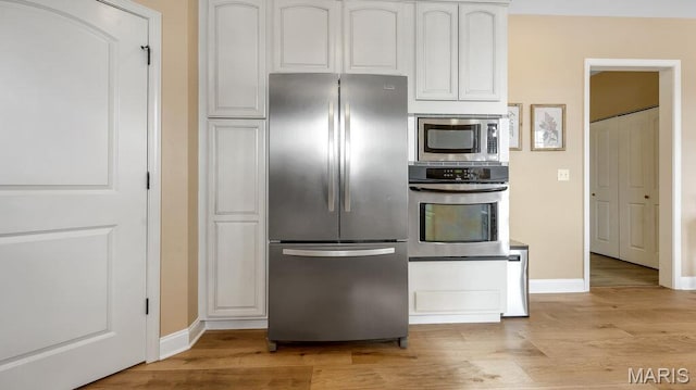 304 Wood Duck Ct, Waterloo, IL 62298 - kitchen featuring appliances with stainless steel finishes, light wood-style flooring, baseboards, and white cabinetry