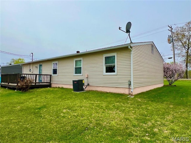 rear view of property with a wooden deck, cooling unit, and a yard