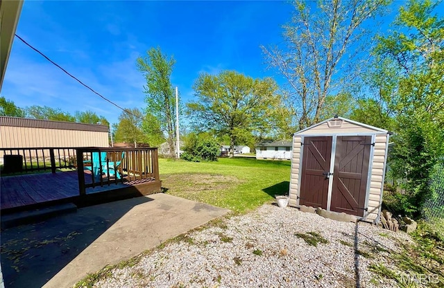 view of green lawn with a storage unit, a wooden deck, and an outbuilding