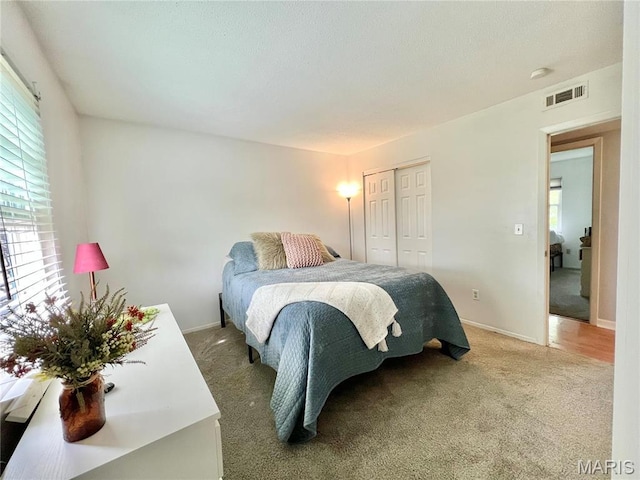 bedroom featuring light carpet, a closet, and baseboards
