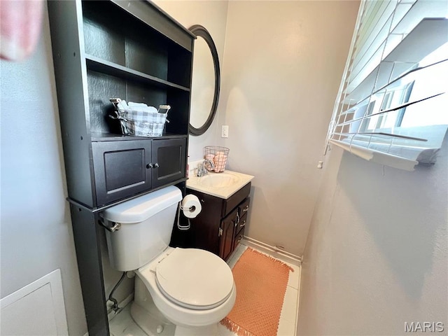 bathroom with baseboards, toilet, vanity, and tile patterned flooring