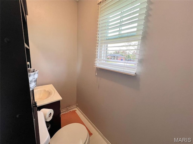 bathroom featuring vanity, baseboards, and toilet