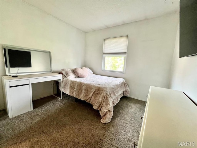 bedroom with dark carpet and baseboards