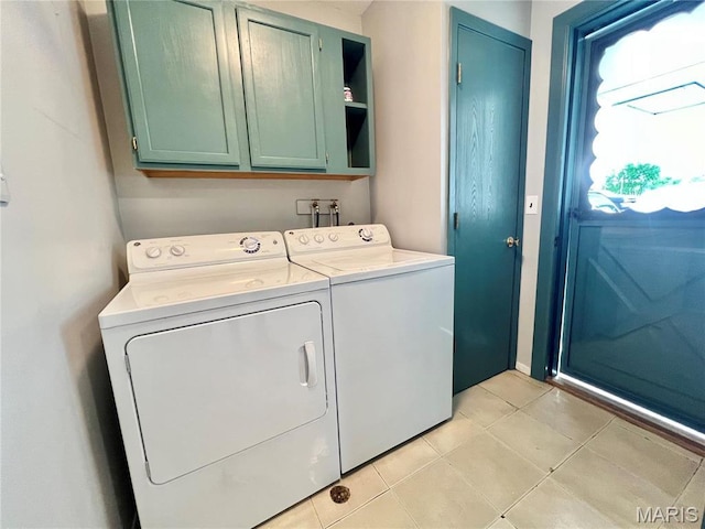 washroom with cabinet space, independent washer and dryer, and light tile patterned floors