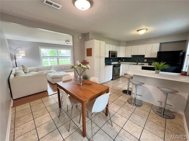 dining area with light tile patterned floors and a textured ceiling