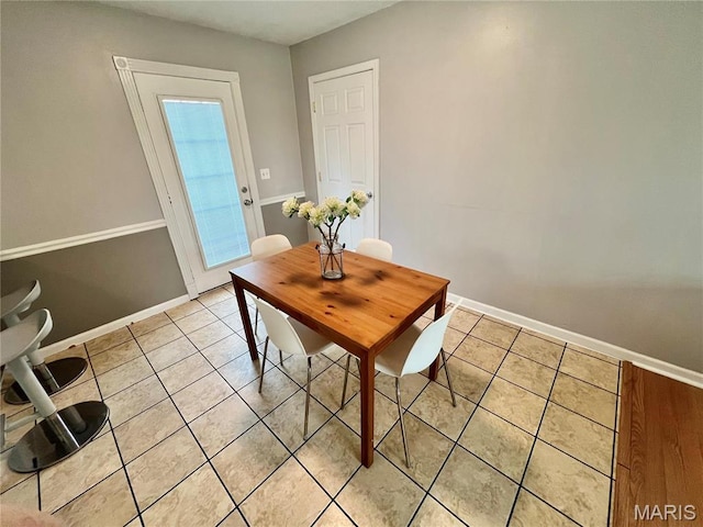dining room with light tile patterned floors and baseboards