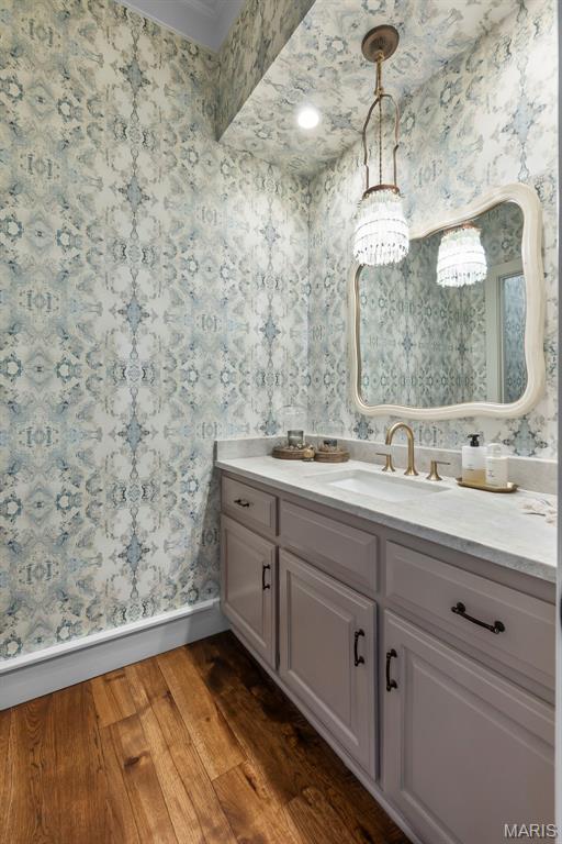323 White Oaks Ln, Cape Girardeau, MO 63701 - bathroom with wallpapered walls, baseboards, vanity, and wood finished floors