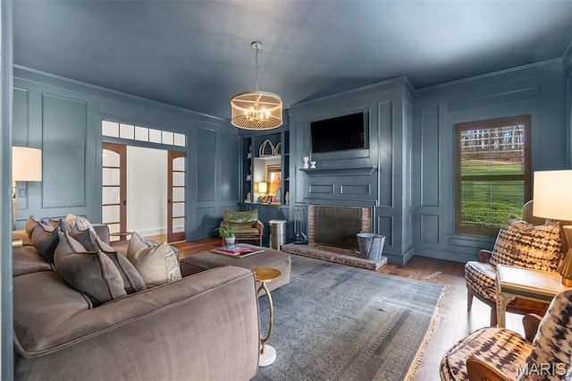 323 White Oaks Ln, Cape Girardeau, MO 63701 - living area featuring a decorative wall, wood finished floors, ornamental molding, a fireplace, and a chandelier