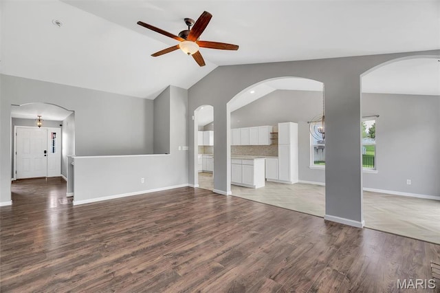 283 Sonnet Cir, Wentzville, MO 63385 - unfurnished living room featuring ceiling fan, wood finished floors, baseboards, high vaulted ceiling, and arched walkways