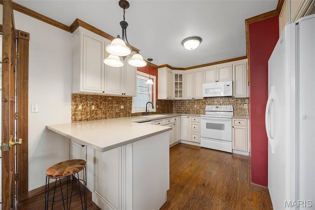 kitchen with white appliances, a sink, a peninsula, dark wood-type flooring, and backsplash