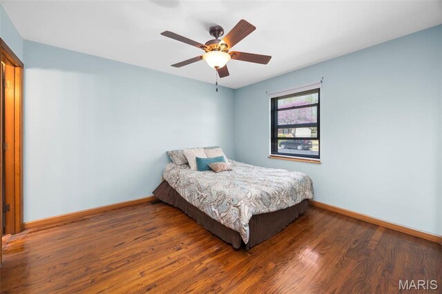 bedroom featuring baseboards, wood finished floors, and ceiling fan