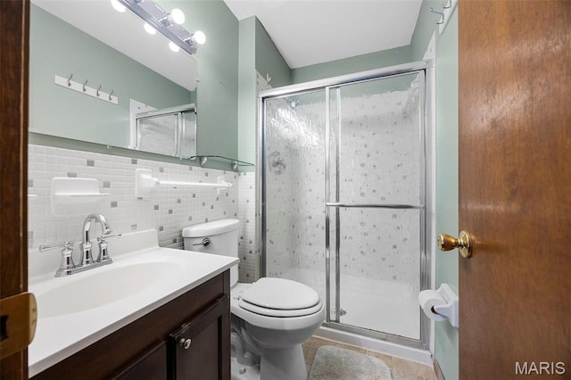 full bathroom featuring a shower stall, toilet, vanity, and tile walls