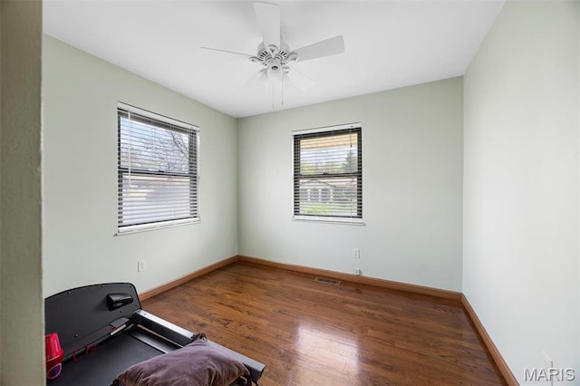 workout room with wood finished floors, baseboards, and ceiling fan