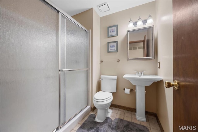 bathroom with tile patterned floors, toilet, a stall shower, and baseboards