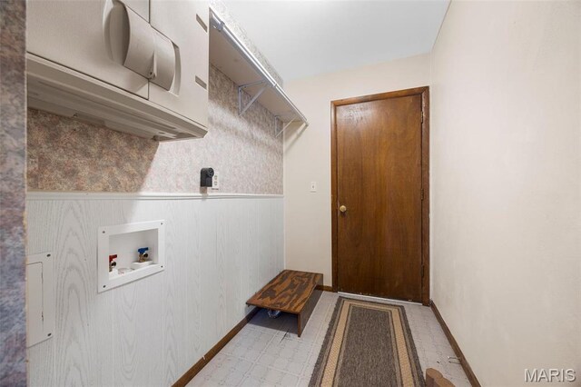 clothes washing area featuring hookup for a washing machine, light flooring, a wainscoted wall, and baseboards