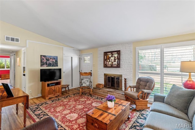1500 Ridgewood Dr, Saint Louis, MO 63126 - living area featuring lofted ceiling, light wood finished floors, healthy amount of natural light, and a brick fireplace