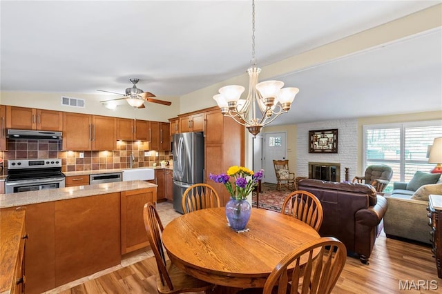 1500 Ridgewood Dr, Saint Louis, MO 63126 - dining area featuring light wood-type flooring, ceiling fan, a chandelier, and a fireplace