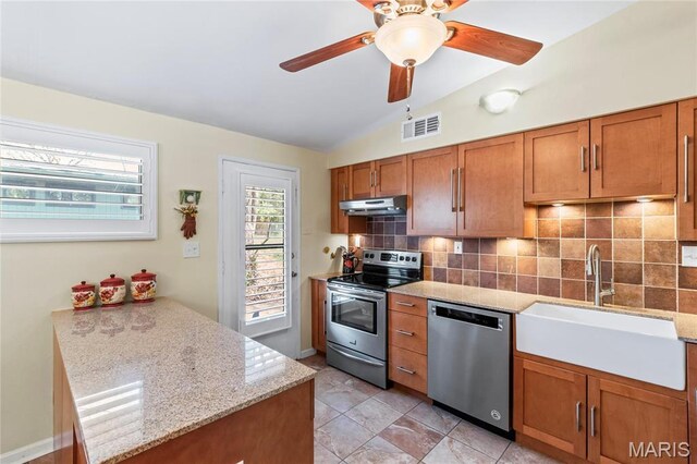 1500 Ridgewood Dr, Saint Louis, MO 63126 - kitchen featuring appliances with stainless steel finishes, under cabinet range hood, vaulted ceiling, a sink, and brown cabinetry
