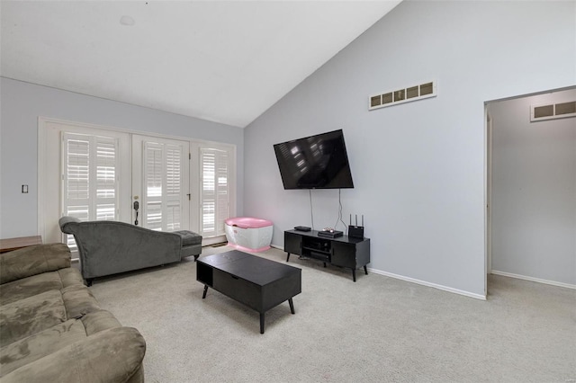 carpeted living room with high vaulted ceiling and baseboards