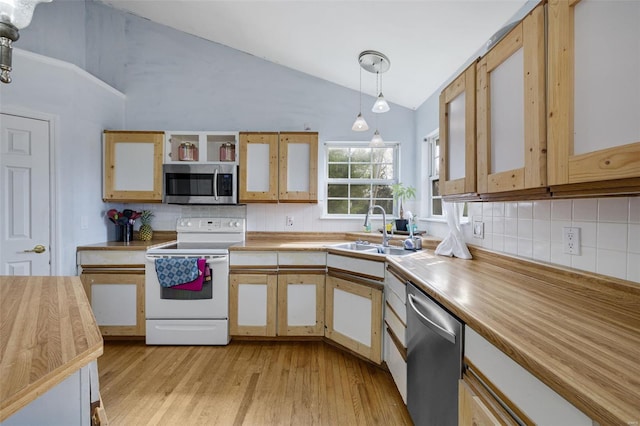 kitchen with stainless steel appliances, backsplash, a sink, light wood-type flooring, and high vaulted ceiling