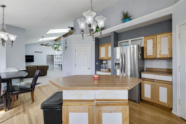 kitchen featuring a chandelier, stainless steel fridge, a skylight, ceiling fan, and light wood finished floors
