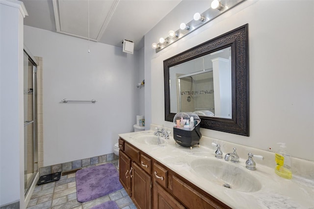 bathroom with a stall shower, double vanity, and toilet