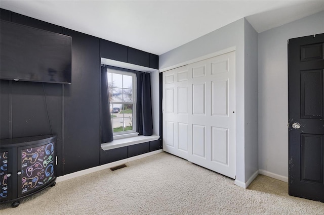 unfurnished bedroom with carpet floors, a closet, and baseboards