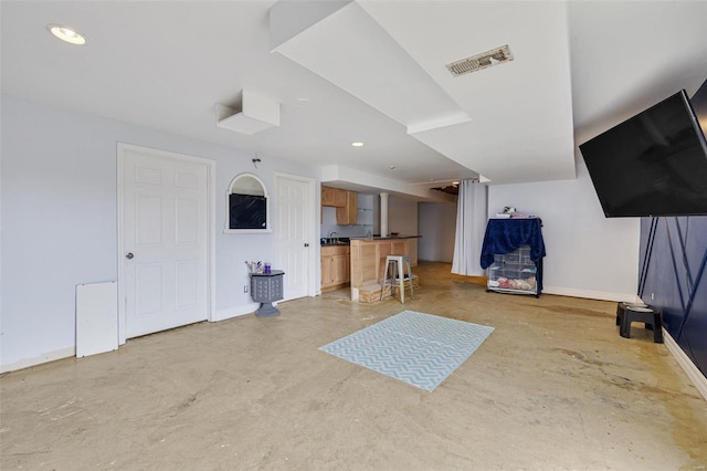 living room with concrete flooring, baseboards, bar area, and recessed lighting