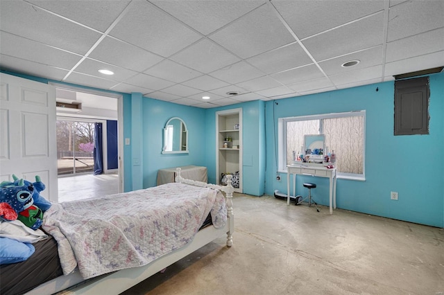 bedroom featuring a drop ceiling, electric panel, recessed lighting, and concrete flooring