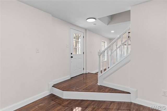 foyer entrance featuring stairway, baseboards, wood finished floors, and recessed lighting