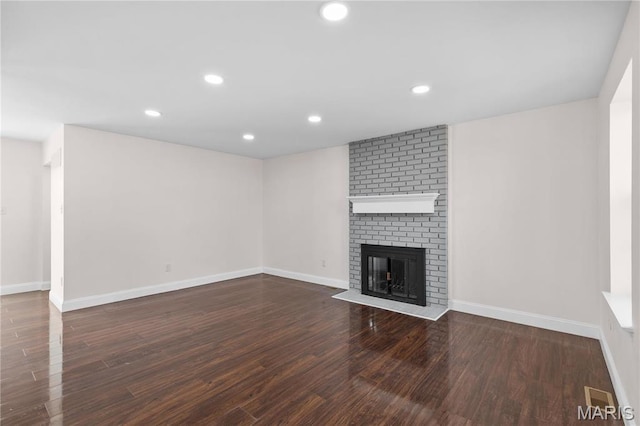 unfurnished living room featuring wood finished floors, a fireplace, baseboards, and recessed lighting