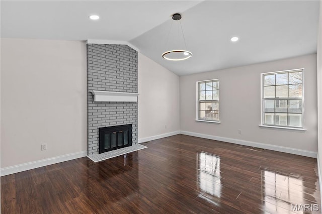 unfurnished living room featuring wood finished floors, vaulted ceiling, a fireplace, baseboards, and recessed lighting