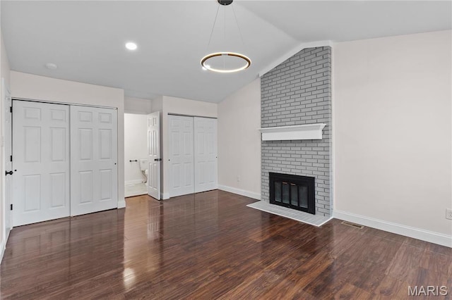 unfurnished living room featuring wood finished floors, baseboards, a fireplace, and lofted ceiling
