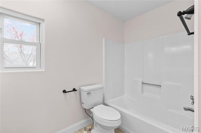 full bath featuring baseboards, toilet, and washtub / shower combination